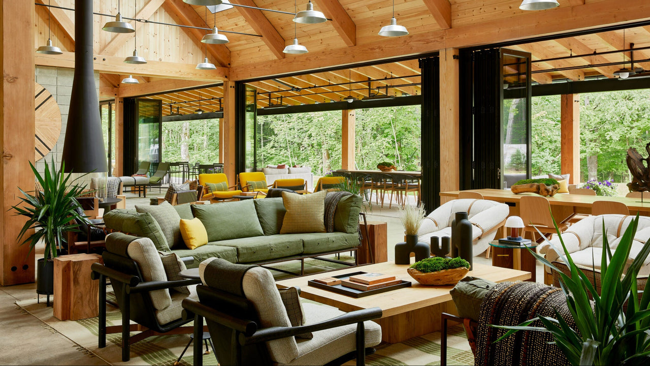  Autocamp Catskills lobby, open and bright with wooden beams, large windows, and comfortable furniture.