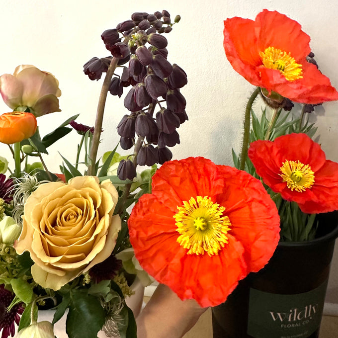  Bouquet of flowers with red and yellow flowers and a visible brand name on a white background